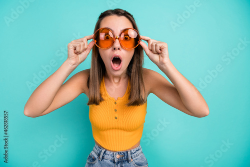 Photo of shocked amazed young woman wear sunglass summer vacation season sale isolated on teal color background