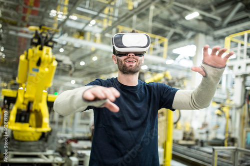 Man wearing VR glasses in modern factory photo