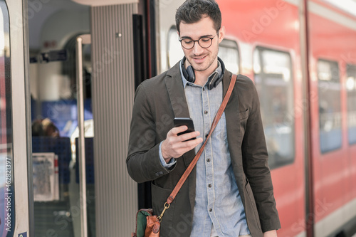 Young man using cell phone at commuter train photo