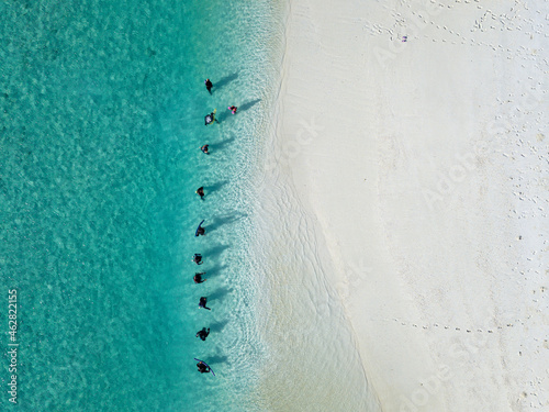 Women in traditional muslim clothes at tropical beach, aerial view photo