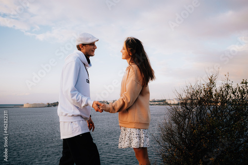 a man and a woman in love at sunset, on the sea embankment