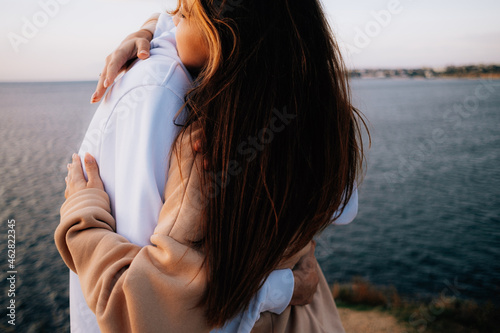 a man and a woman in love at sunset, on the sea embankment