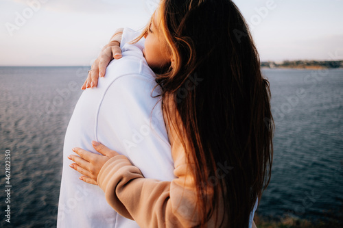 a man and a woman in love at sunset, on the sea embankment