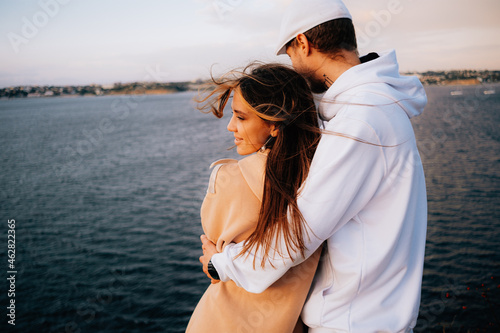 a man and a woman in love at sunset, on the sea embankment