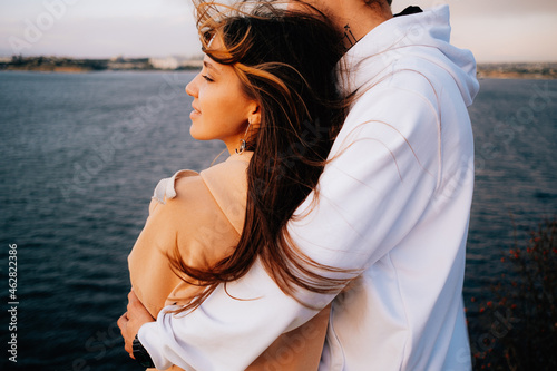 a man and a woman in love at sunset, on the sea embankment