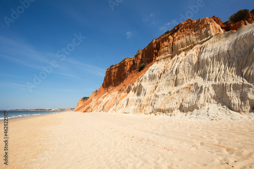 Rocky sandstone coast against sky at Algarve, Portugal photo