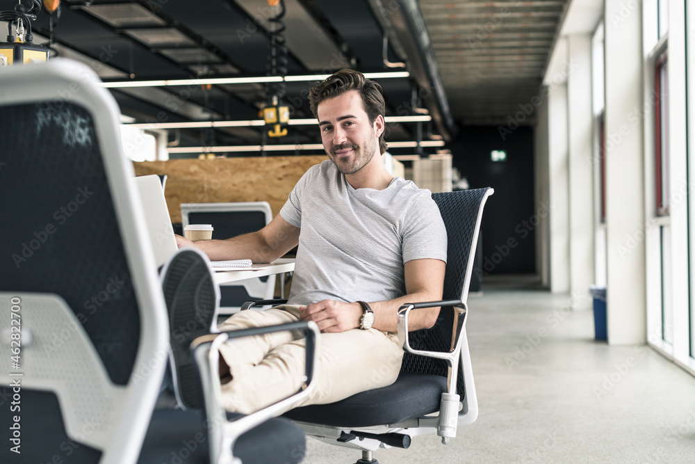 Young businessman working relaxed in modern office Young businessman working relaxed in modern office