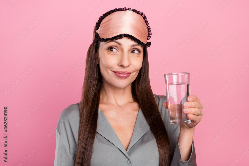 Portrait of attractive curious cheerful woman drinking fresh water good morning isolated over pink pastel color background