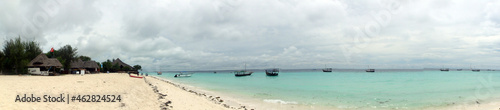 Panorama Photo Of A Cloudy Day At The Beach Of Nungwi In Zanzibar With Locals Boats On The Clear Ocean Water