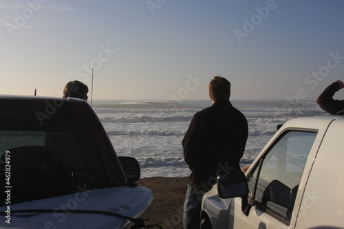 two surfers watching big waves at Ocean Beach in San Francisco