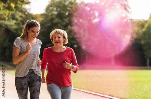 Granddaughter and grandmother having fun, jogging together in the park