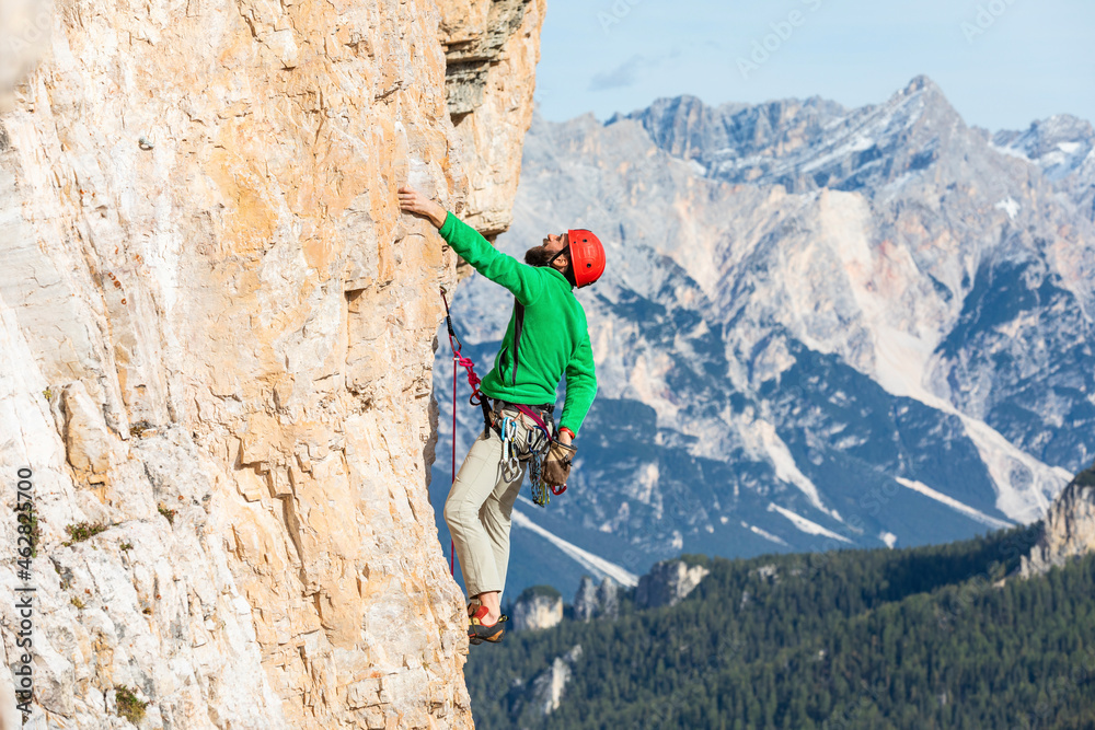 Italy, Cortina d'Ampezzo, man using chalk powder while climbing in the Dolomites mountains
