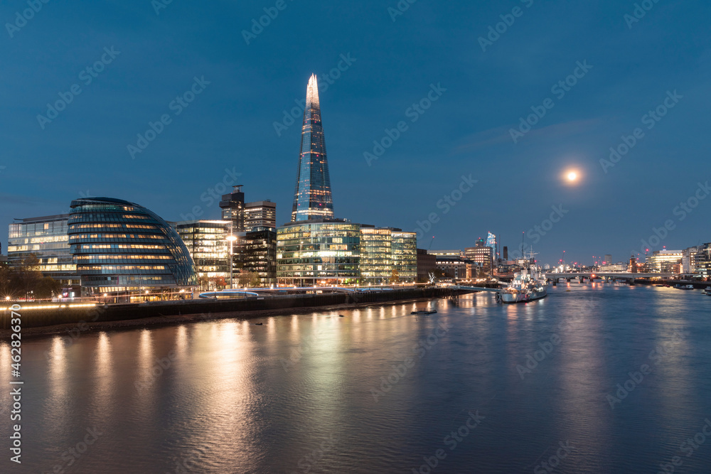 UK, England, London, River Thames and illuminated waterfront skyscrapers at early dawn UK, England, London, River Thames and illuminated waterfront skyscrapers at early dawn