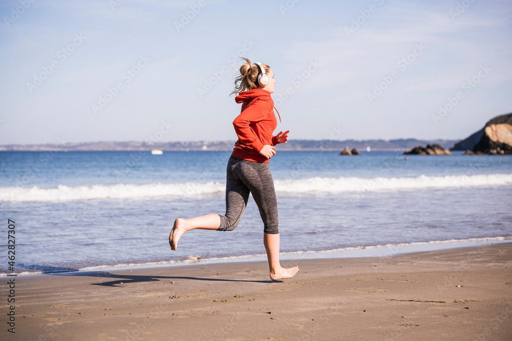 Female jogger at the beach with headphones Female jogger at the beach with headphones
