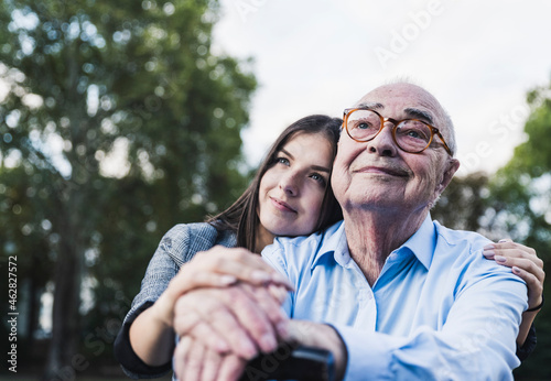 Portrait of senior man and his granddaughter in a park photo