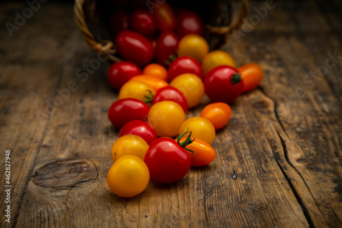 Tomatoes spilling from wicker basket photo