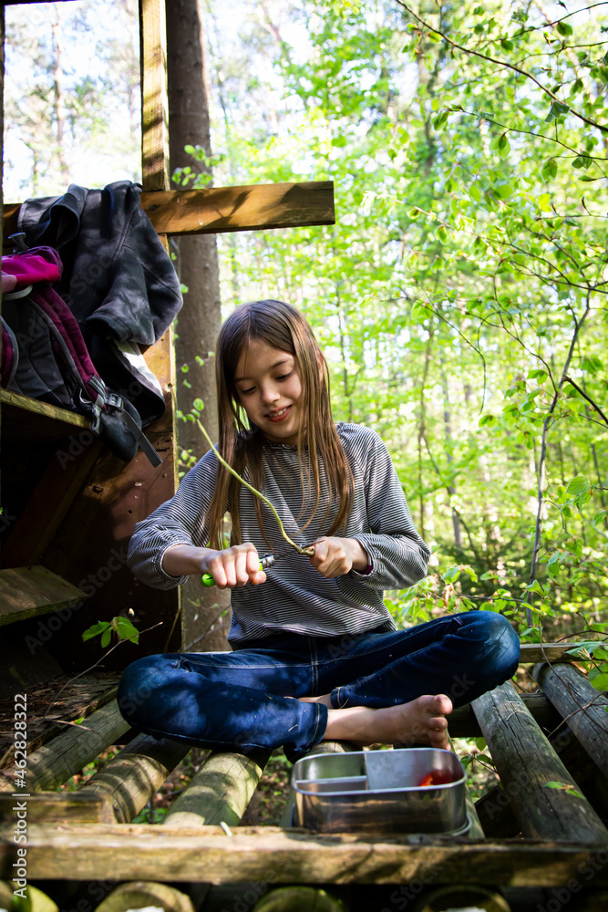 © Westend61 - Girl carving a piece of wood sitting on raised hide in the woods © Westend61 - Girl carving a piece of wood sitting on raised hide in the woods