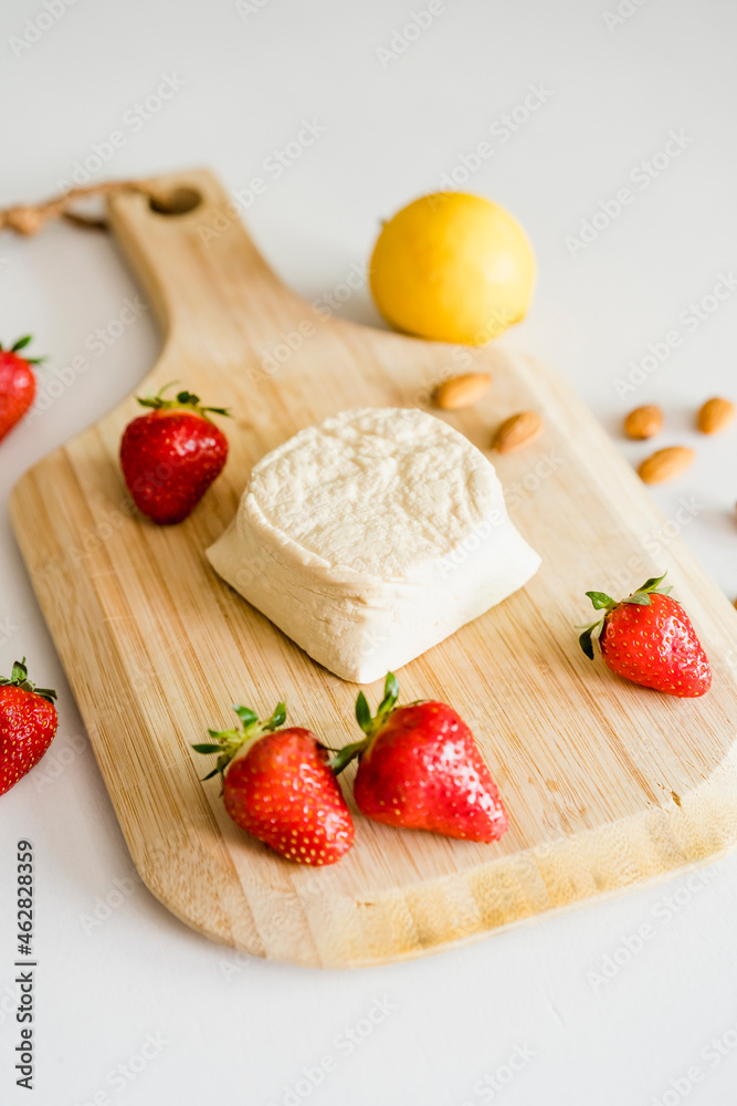 Strawberries and homemade vegan cheesecake on cutting board Strawberries and homemade vegan cheesecake on cutting board