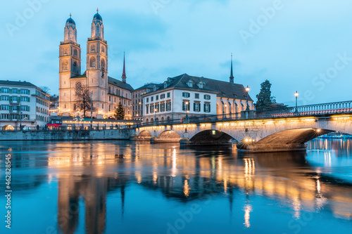 Switzerland, Zurich, Grossmunster church and Munsterbrucke over Limmat river at dusk photo
