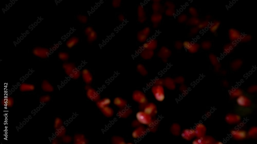 The top view of the pomegranate grains bouncing up on the black background The top view of the pomegranate grains bouncing up on the black background