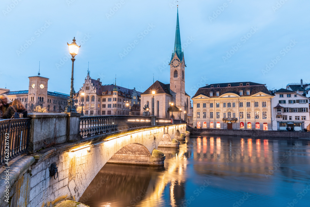 Switzerland, Zurich, Fraumunster church and Munsterbrucke over Limmat river at dusk