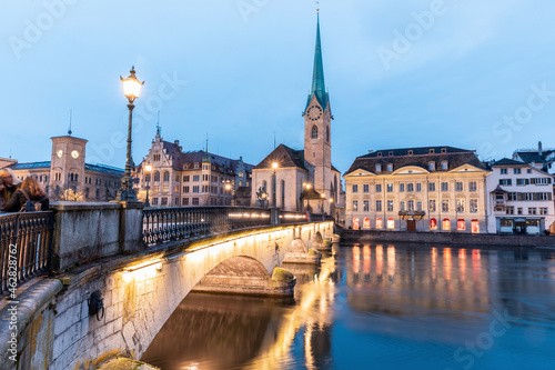 Switzerland, Zurich, Fraumunster church and Munsterbrucke over Limmat river at dusk photo