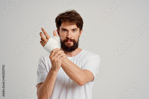 Foto sick man bandaged hand injury to fingers hospitalization isolated background