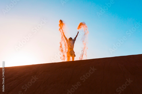 Sultanate Of Oman, Wahiba Sands, Mid adult man is playing with sand in the desert