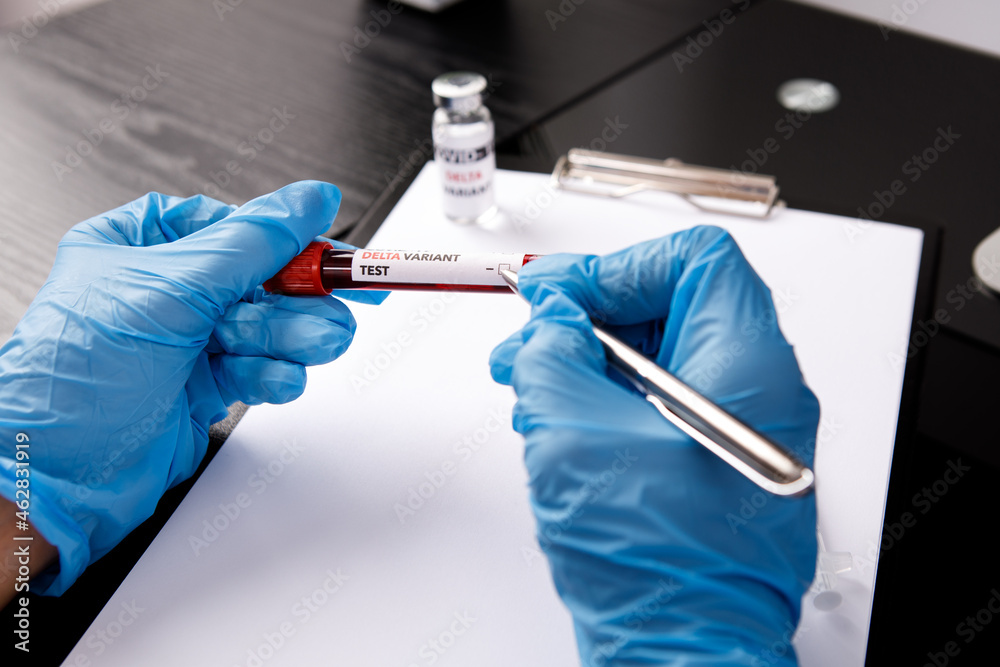 covid 19 delta Variant vaccine and test blood in hand on table background. vaccination against coronavirus
