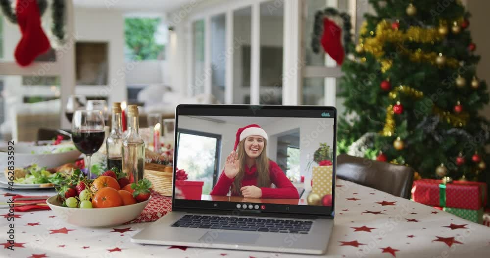 Happy caucasian woman in santa hat on laptop lying on christmas table Happy caucasian woman in santa hat on laptop lying on christmas table
