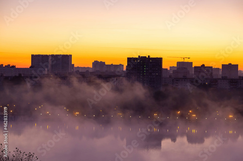 Beautiful orange texture of a misty city on the banks of the river