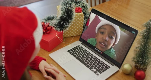 Caucasian woman on video call with african american boy at christmas time photo