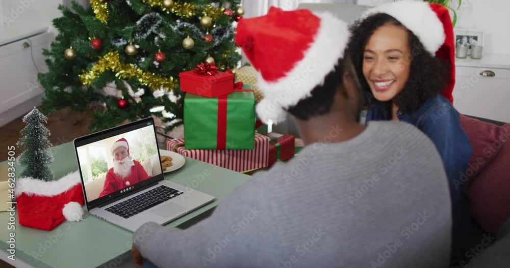 Happy african american couple on video call with santa claus at christmas time Happy african american couple on video call with santa claus at christmas time