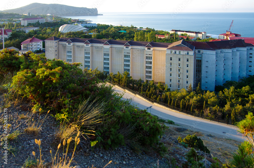 SUDAK, CRIMEA - July, 2020: The street of the city in summer sunny day SUDAK, CRIMEA - July, 2020: The street of the city in summer sunny day