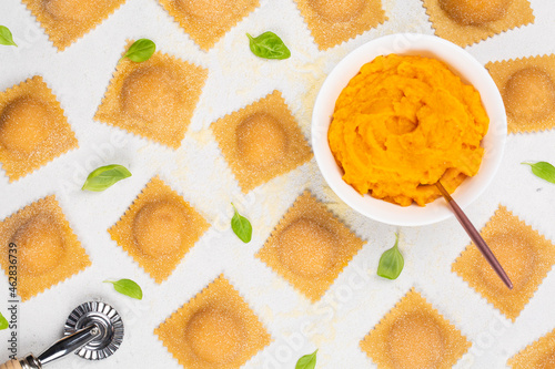 Cooking pumpkin ravioli.   Filling made from pumpkin, egg, bread crumbles, parmesan cheese and nutmeg. Raw egg pasta. Basil liaves. photo