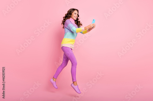 Full length profile side photo of young girl go jumper take selfie isolated over pastel color background © deagreez