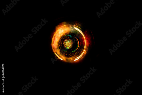 Abstract light circular nebula with light dust and clouds. Circular energy field with burning effect and black background. Warm color with orange and yellow in rotating lights