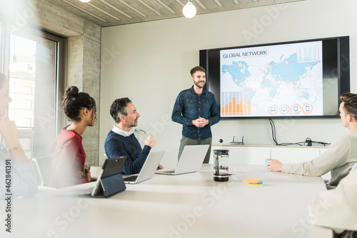 Young businessman leading a presentation in boardroom photo