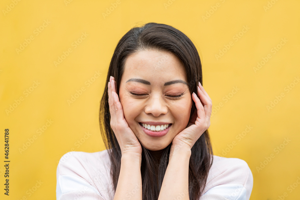 Portrait of happy woman with eyes closed against yellow background Portrait of happy woman with eyes closed against yellow background