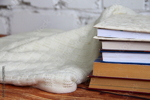 Stack of books and a cozy sweater near