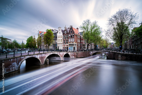 Netherlands, Amsterdam, Light trails along city canal photo