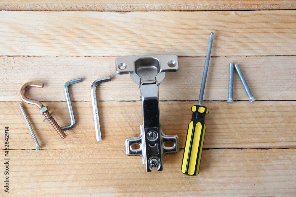 Set of tools and accessories for assembling furniture on the wooden background Set of tools and accessories for assembling furniture on the wooden background
