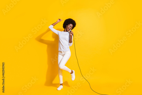 Full body portrait of pretty positive dark skin person open mouth singing loud isolated on yellow color background