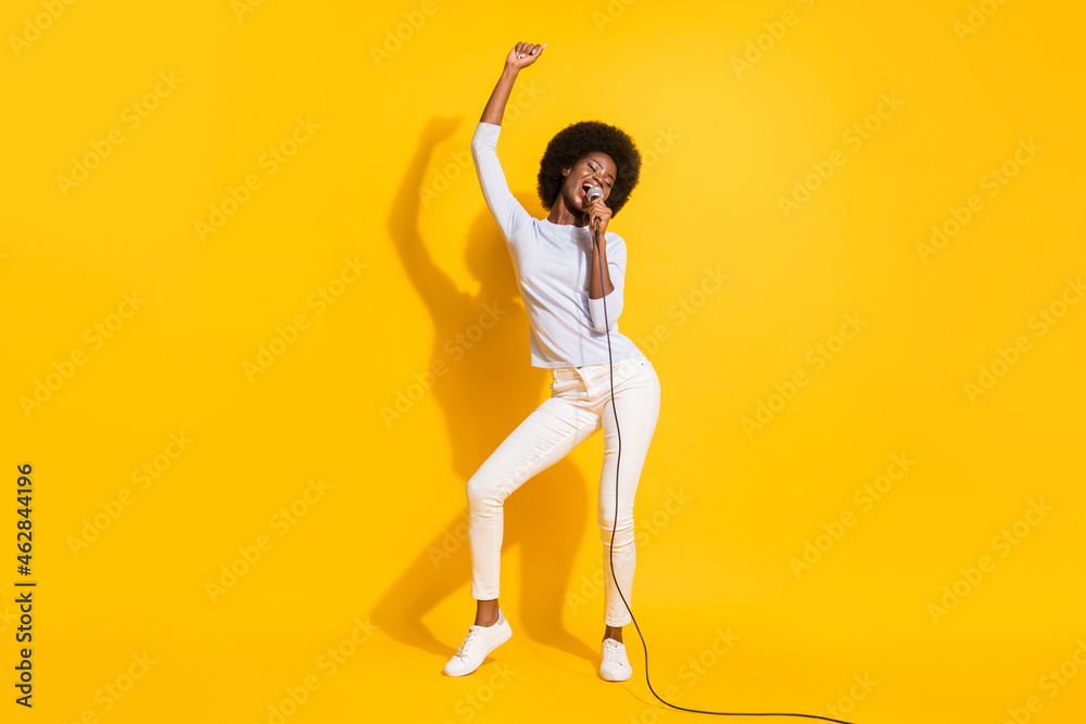 Full size portrait of excited positive dark skin lady closed eyes have fun singing isolated on yellow color background