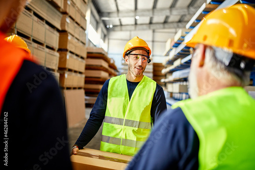 Workers talking in factory warehouse photo