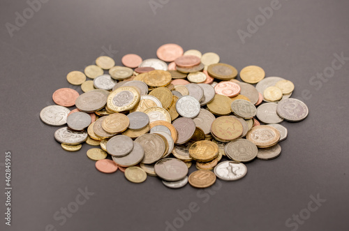 Different money coins. US dollars money and euro as a background on a flat lay. Savings and economy. Coins of different denominations from different countries. Inflation and exchange rates.