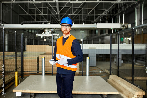 Portrait of worker with tablet in factory warehouse photo