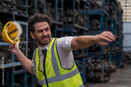 The manager in the industrial plant was furious. Man with angry gesture in parts warehouse.