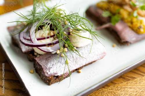 Smorrebrod sandwich in  Smorgasbord buffet, scandinavian typical open sandwich with hering and beef carpaccio. Fresh and healthy food in north europe photo