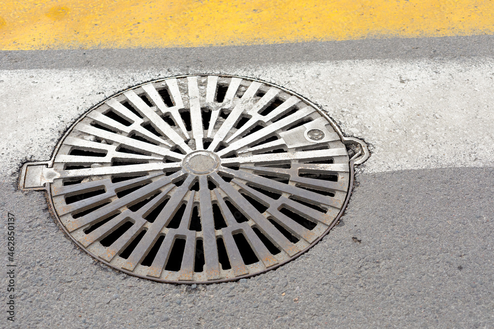 sewer hatch at a pedestrian crossing. close-up. sewer hatch at a pedestrian crossing. close-up.